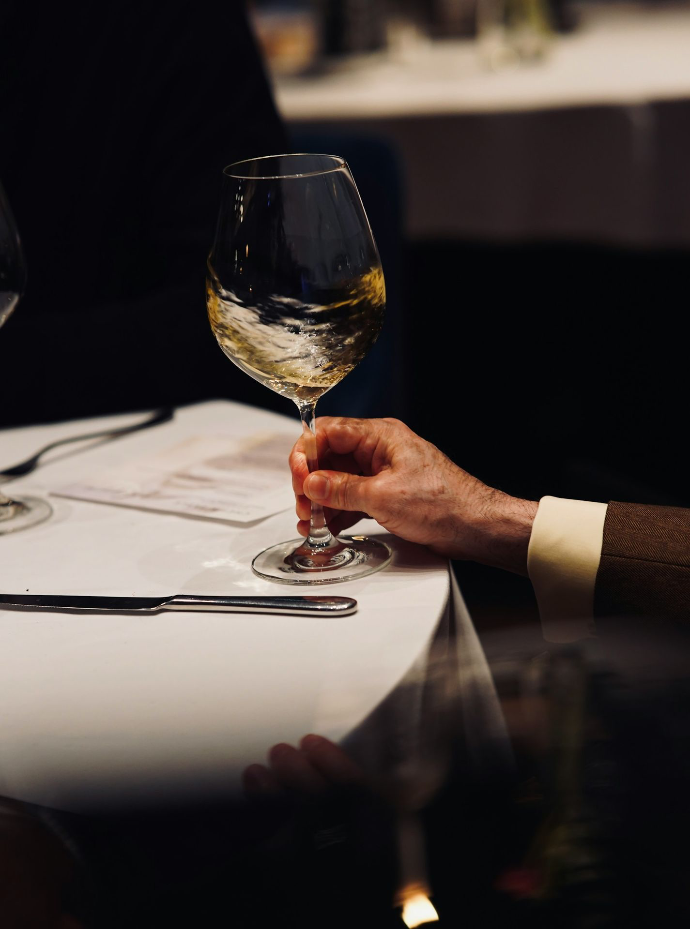 A couple of people sitting at a table with wine glasses